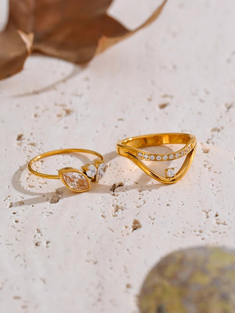 Goldfarbene Ringe mit Zirkonia, zwei Ausführungen auf hellem Stein – Charmhabit