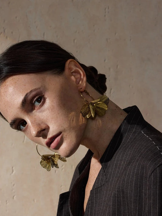 Large hoop earrings with a metal flower, worn – Charmhabit