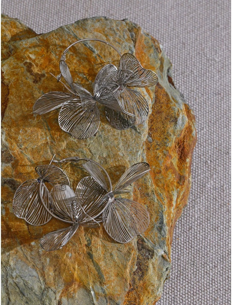 Große Creolen mit Metallblume, silberfarben, auf einem Stein – Charmhabit