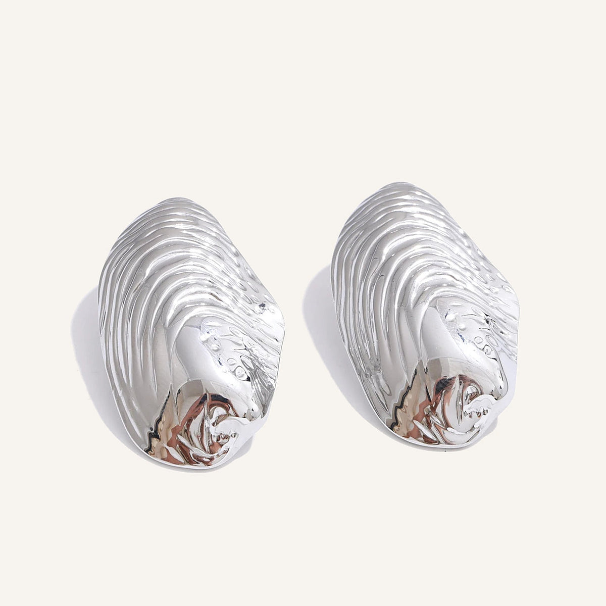 Large ribbed shell-shaped stud earrings, silver tone, on a light background – Charmhabit