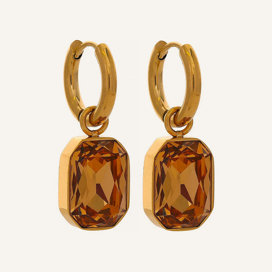 Huggie hoops with an octagonal crystal pendant in champagne, on a light background – Charmhabit