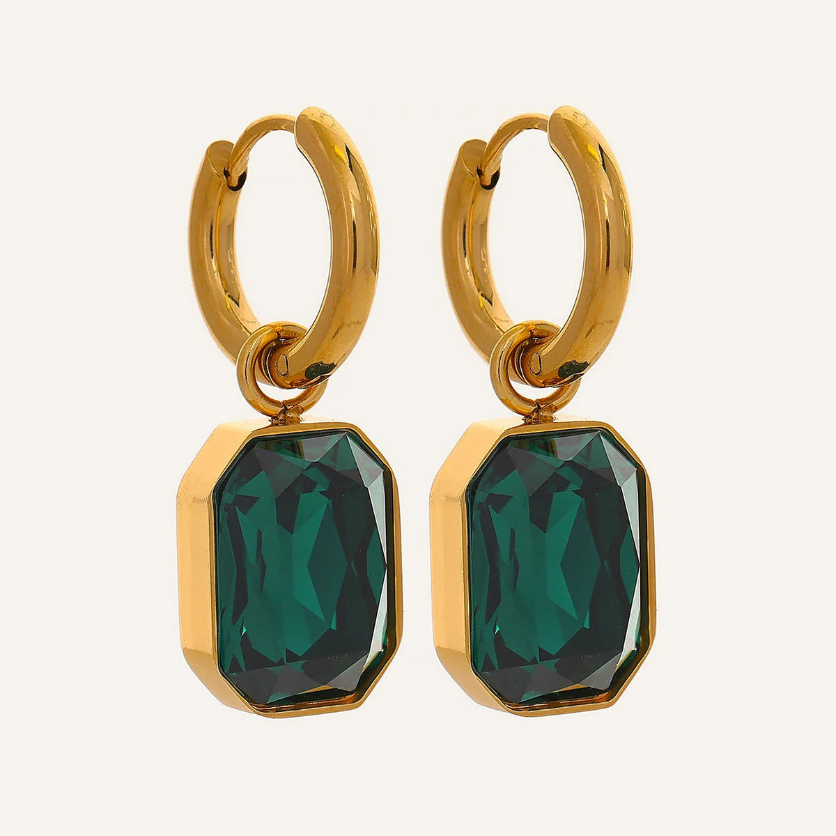 Huggie hoops with an octagonal crystal pendant in green, on a light background – Charmhabit