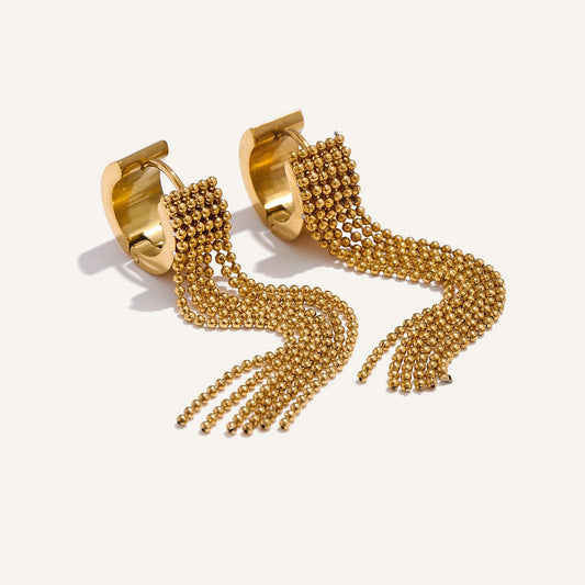 Huggie hoops with ball chain fringe, gold tone, on a light background – Charmhabit