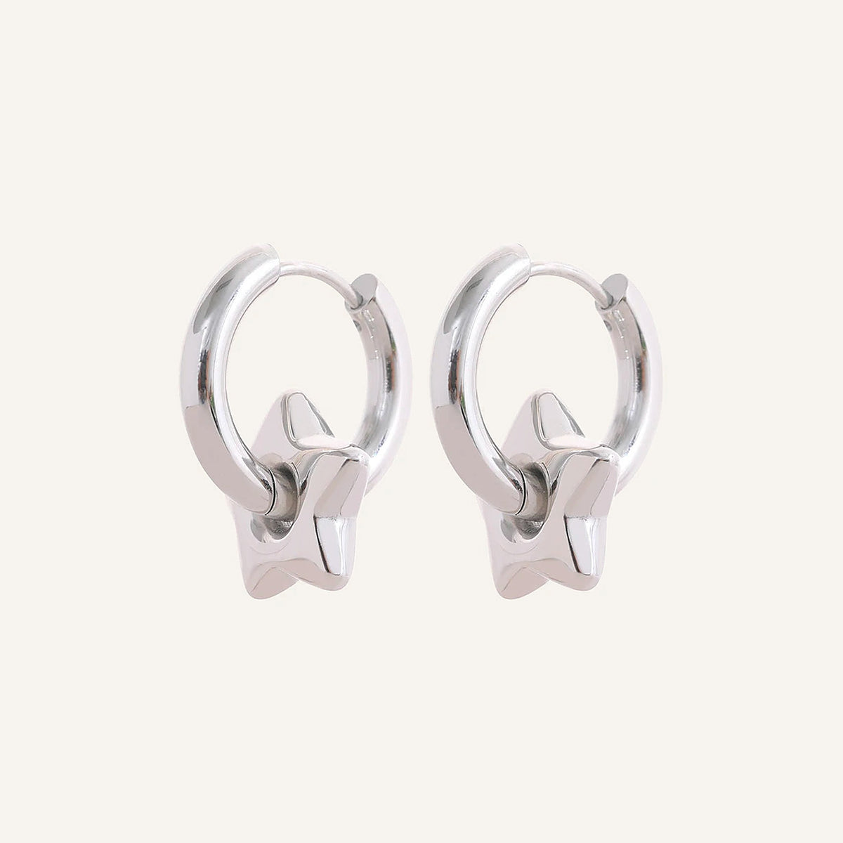 Huggie hoops with star charm, silver tone, on a light background – Charmhabit