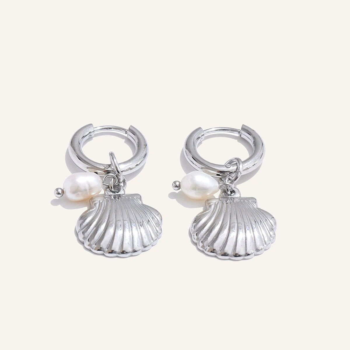 Huggie hoops with sea charm and pearl, shell, silver tone, on a light background – Charmhabit