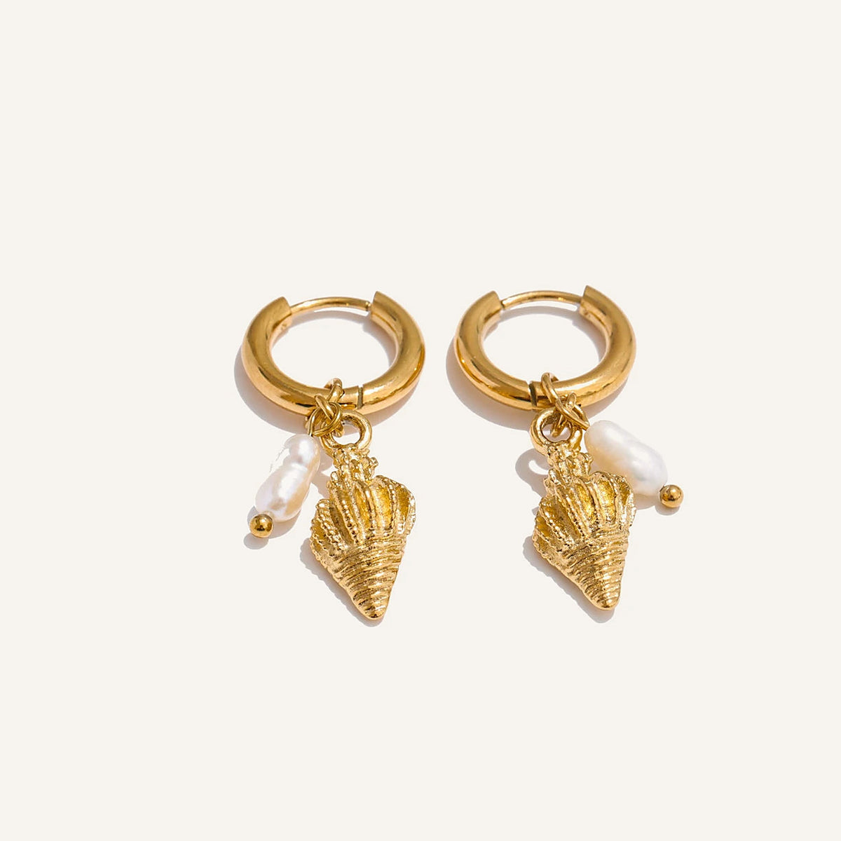 Huggie hoops with sea charm and pearl, horn, gold tone, on a light background – Charmhabit