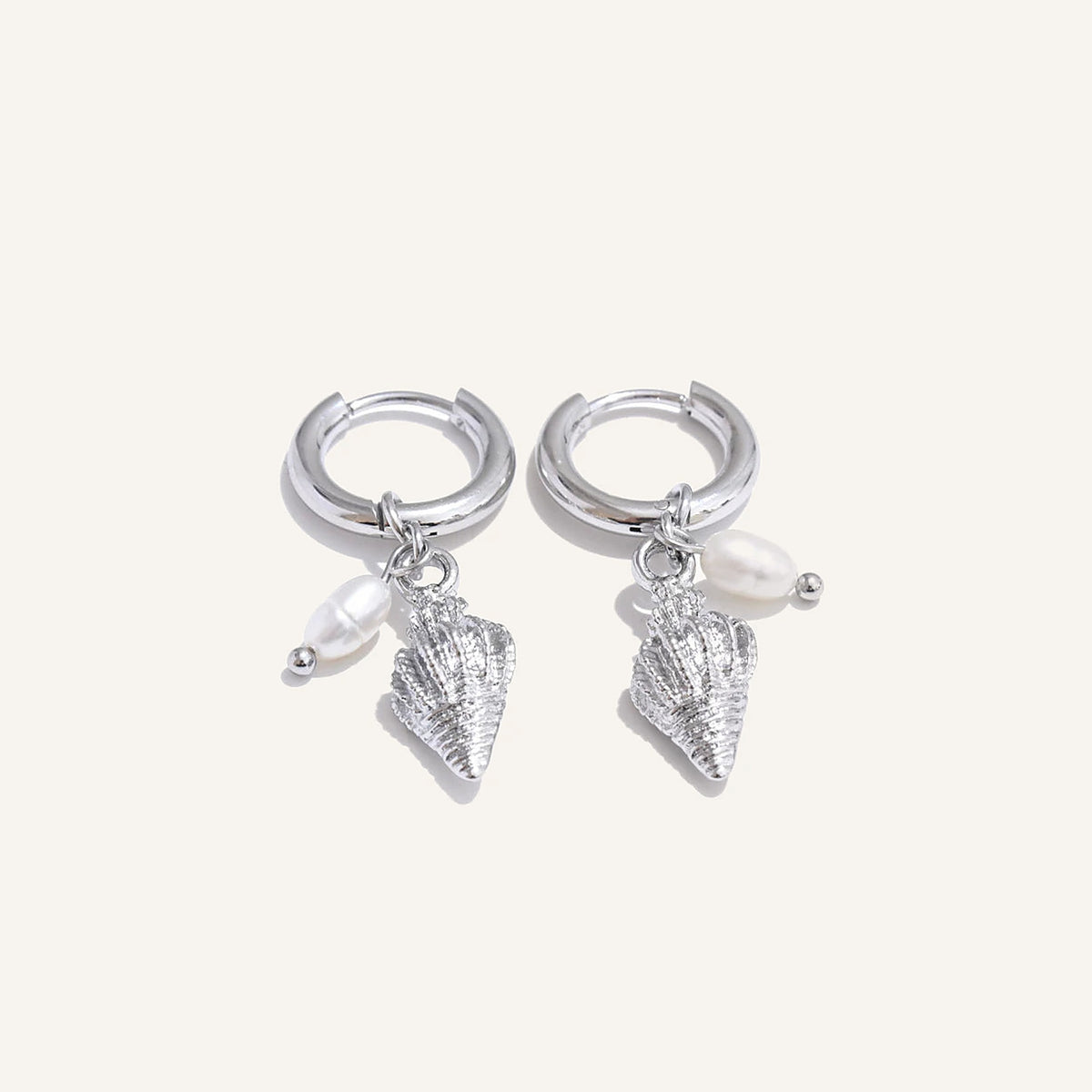 Huggie hoops with sea charm and pearl, horn, silver tone, on a light background – Charmhabit