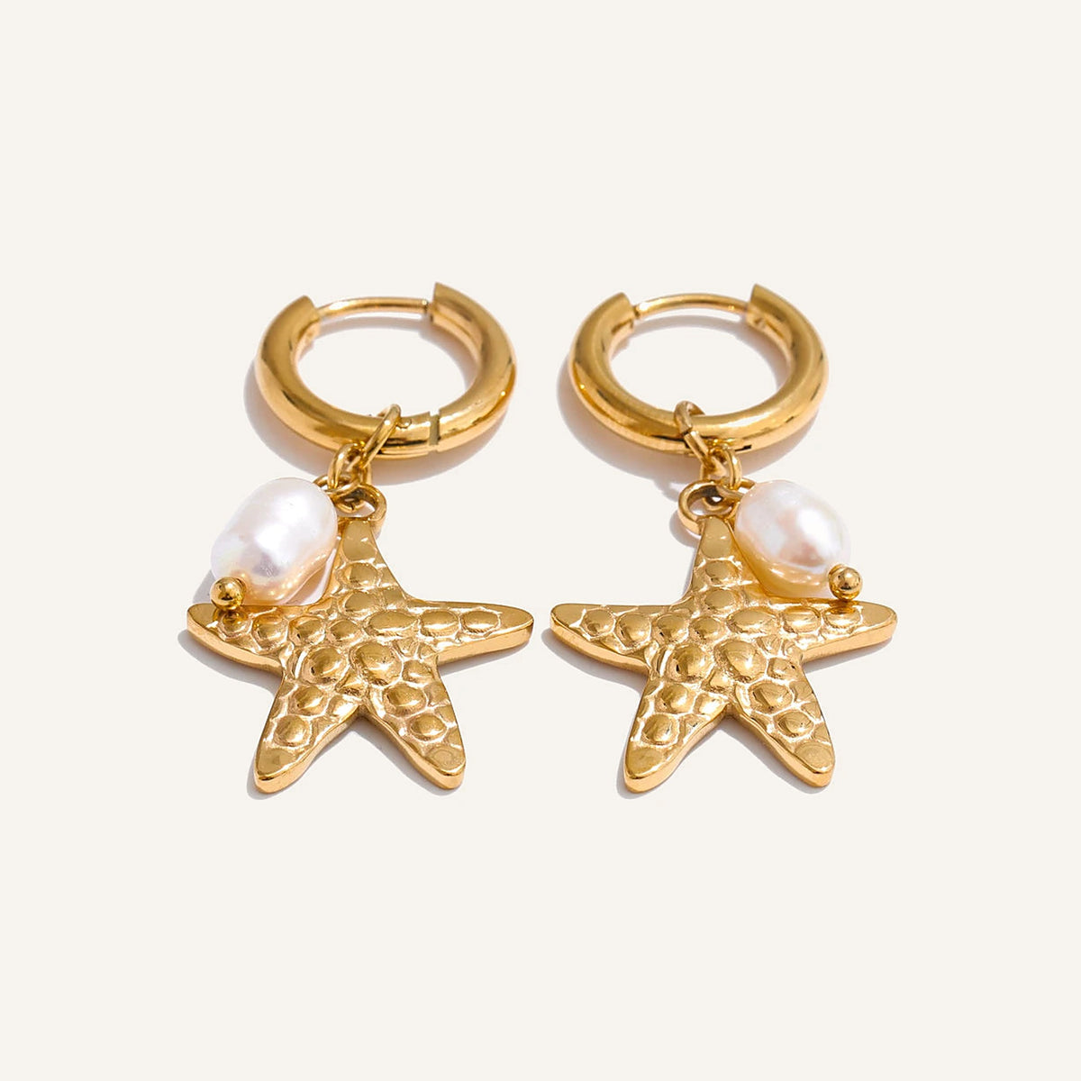 Huggie hoops with sea charm and pearl, starfish, gold tone, on a light background – Charmhabit