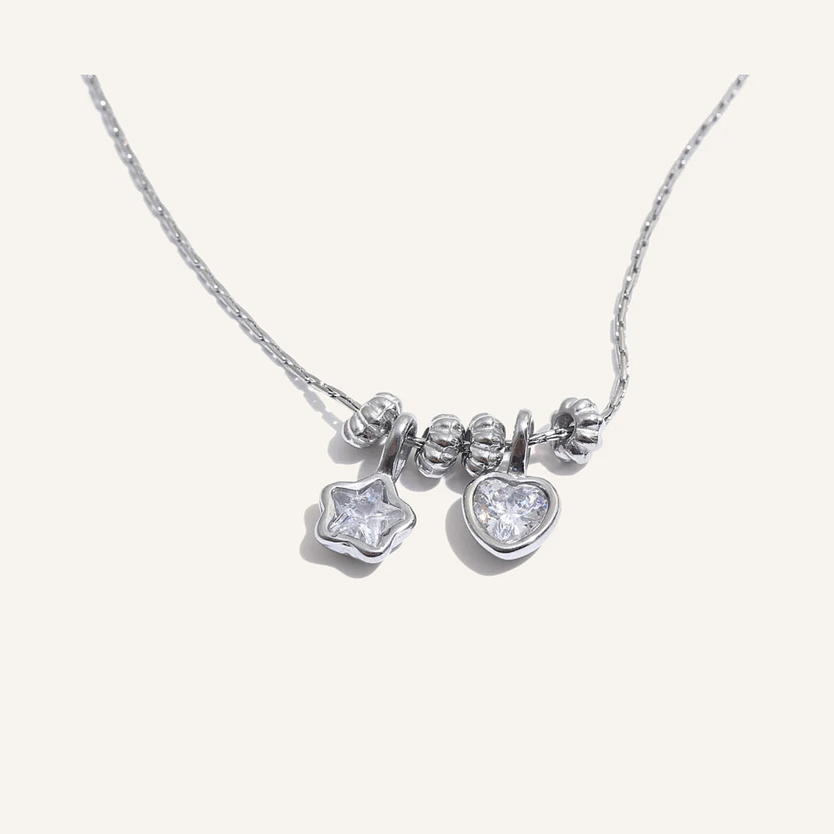 Necklace with heart and star charms, silver tone, on a light background – Charmhabit