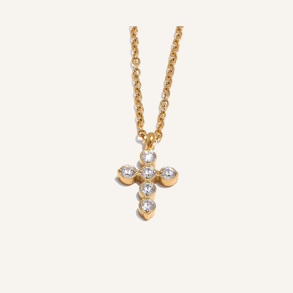 Necklace with cross and zirconia, gold tone, on a light background – Charmhabit