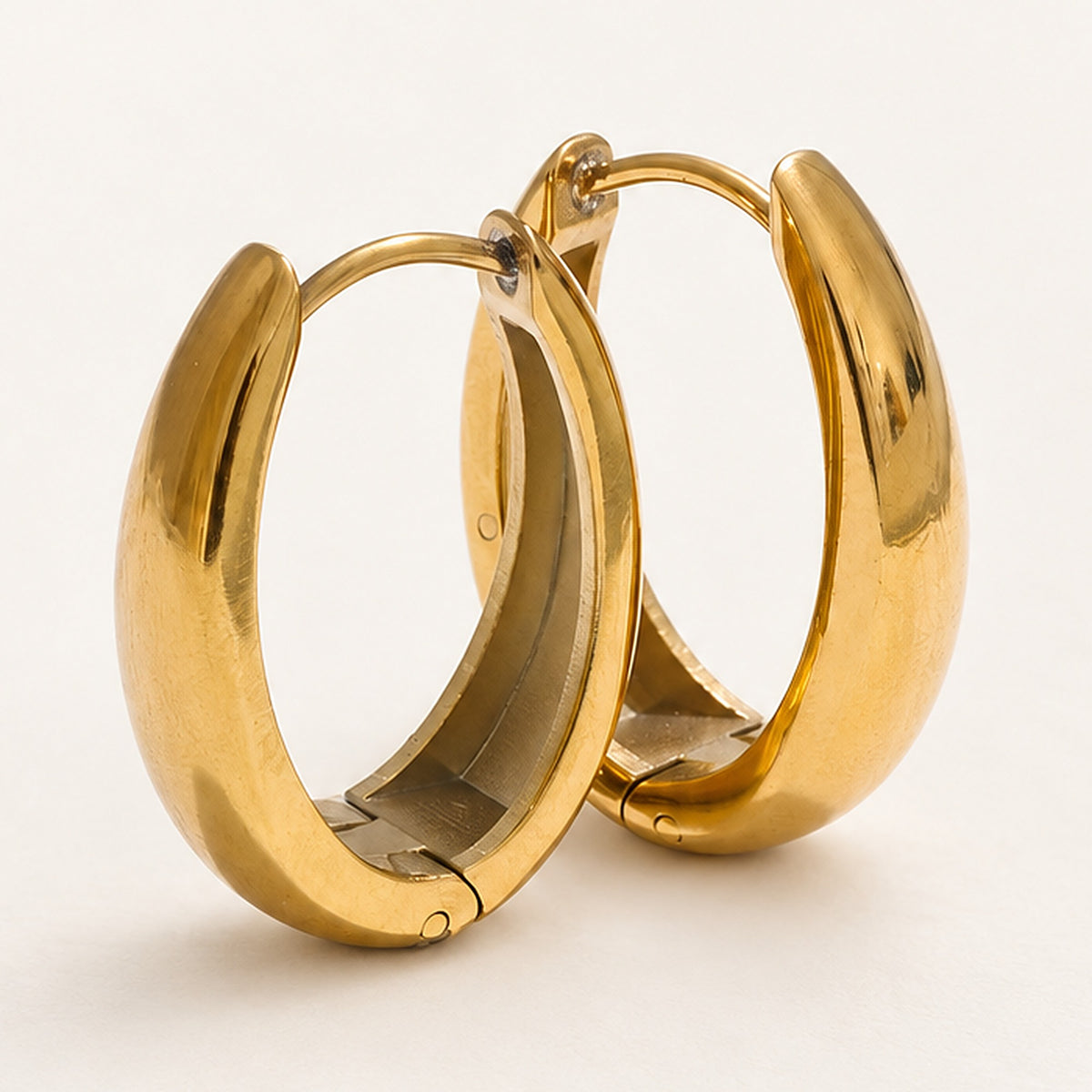 Close-up of small hoop earrings, gold tone, with hinged closure – Charmhabit