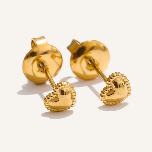Mini-Ohrstecker in Herzform, goldfarben, auf hellem Hintergrund – Charmhabit