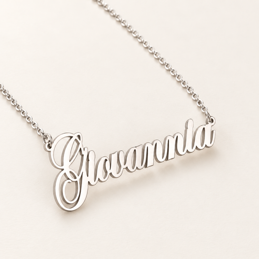 Zilverkleurige naamketting met de voorbeeldnaam Giovannia op een rustige ivoorkleurige achtergrond