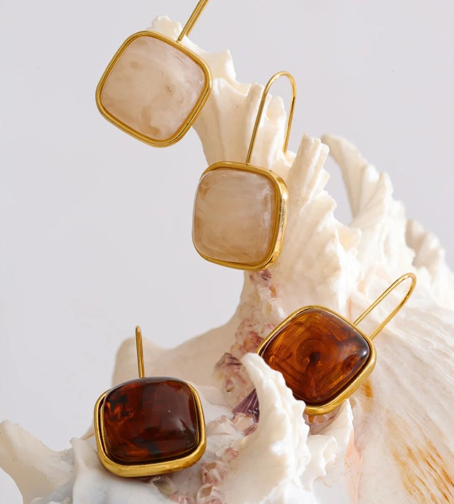 Pendants d'oreilles avec pierre carrée en résine près d'un coquillage – Charmhabit