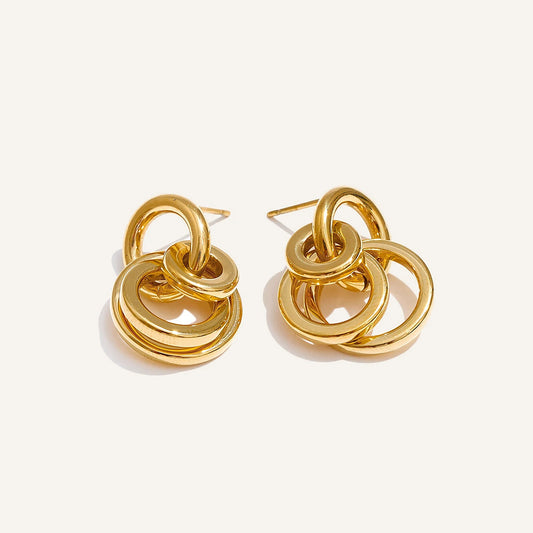 Intertwined circle stud earrings, gold tone, on a light background – Charmhabit