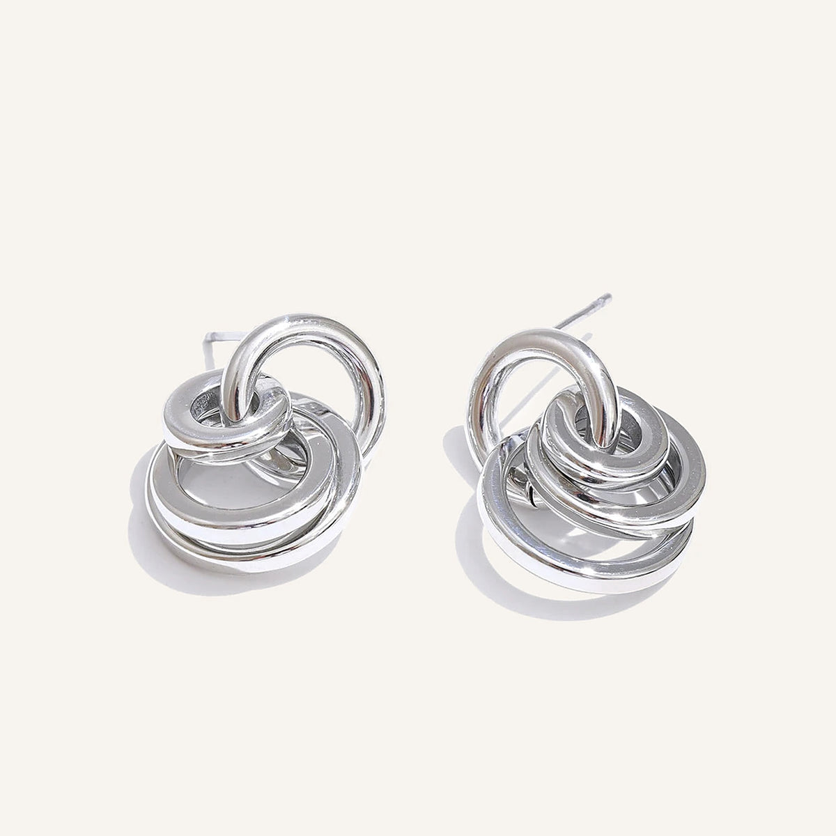 Interlaced circle stud earrings, silver tone, on a light background – Charmhabit