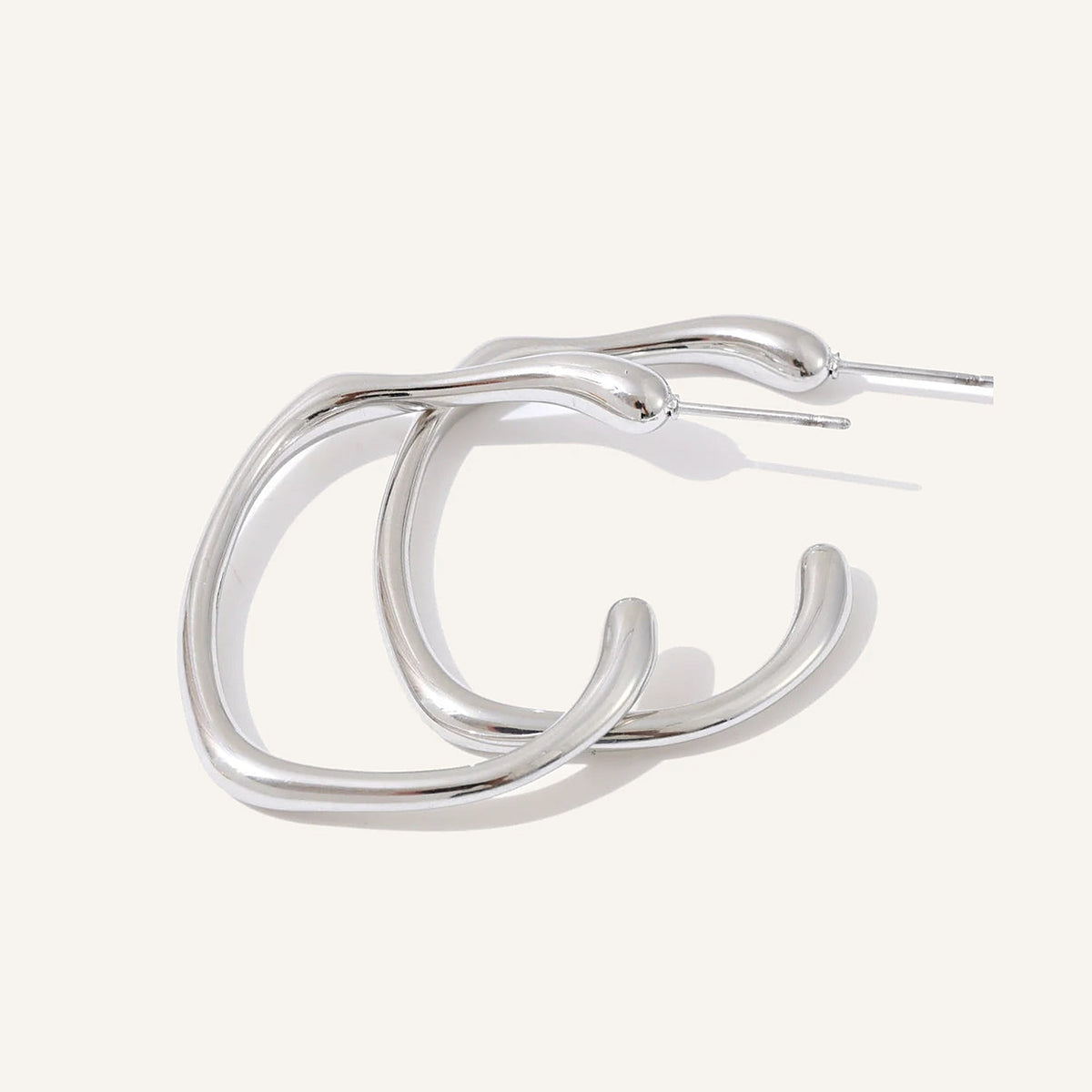 Open C-shaped earrings with a soft curve, silver tone, on a light background – Charmhabit