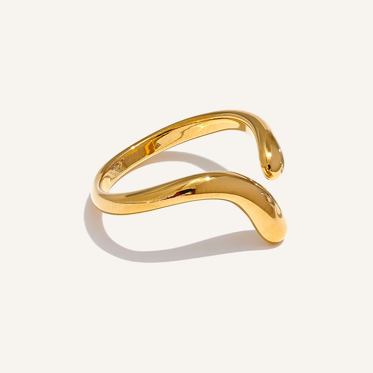 Bague ouverte ondulée, dorée, sur fond clair – Charmhabit