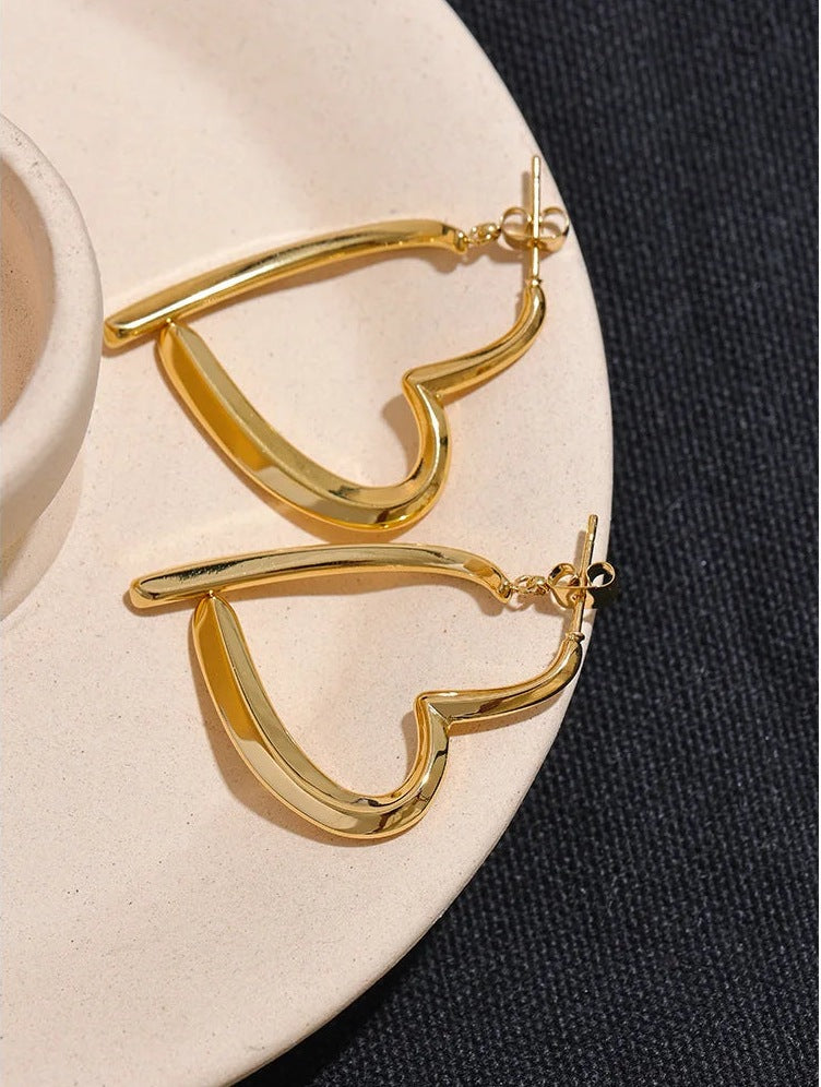Open heart-shaped earrings with a high-gloss finish, gold tone, on a plate – Charmhabit