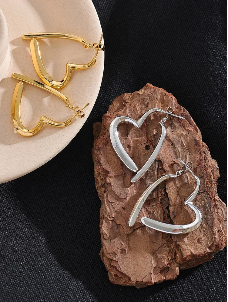 Open heart-shaped earrings with a high-gloss finish in gold and silver tone on bark – Charmhabit