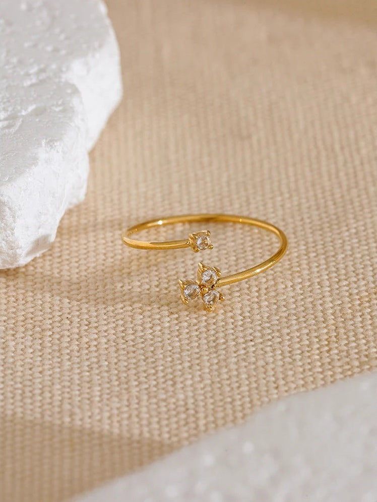 Offener Ring mit vier Zirkonia in Kleeblattform, auf Leinen – Charmhabit