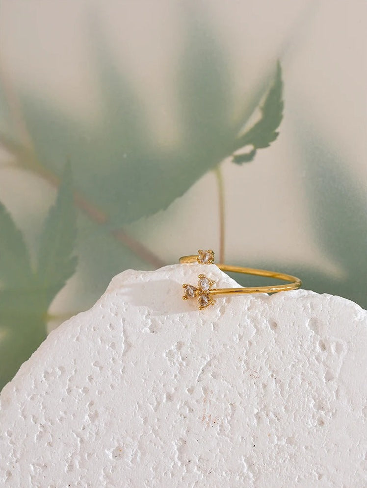 Offener Ring mit vier Zirkonia in Kleeblattform, Stimmungsbild mit Blatt – Charmhabit
