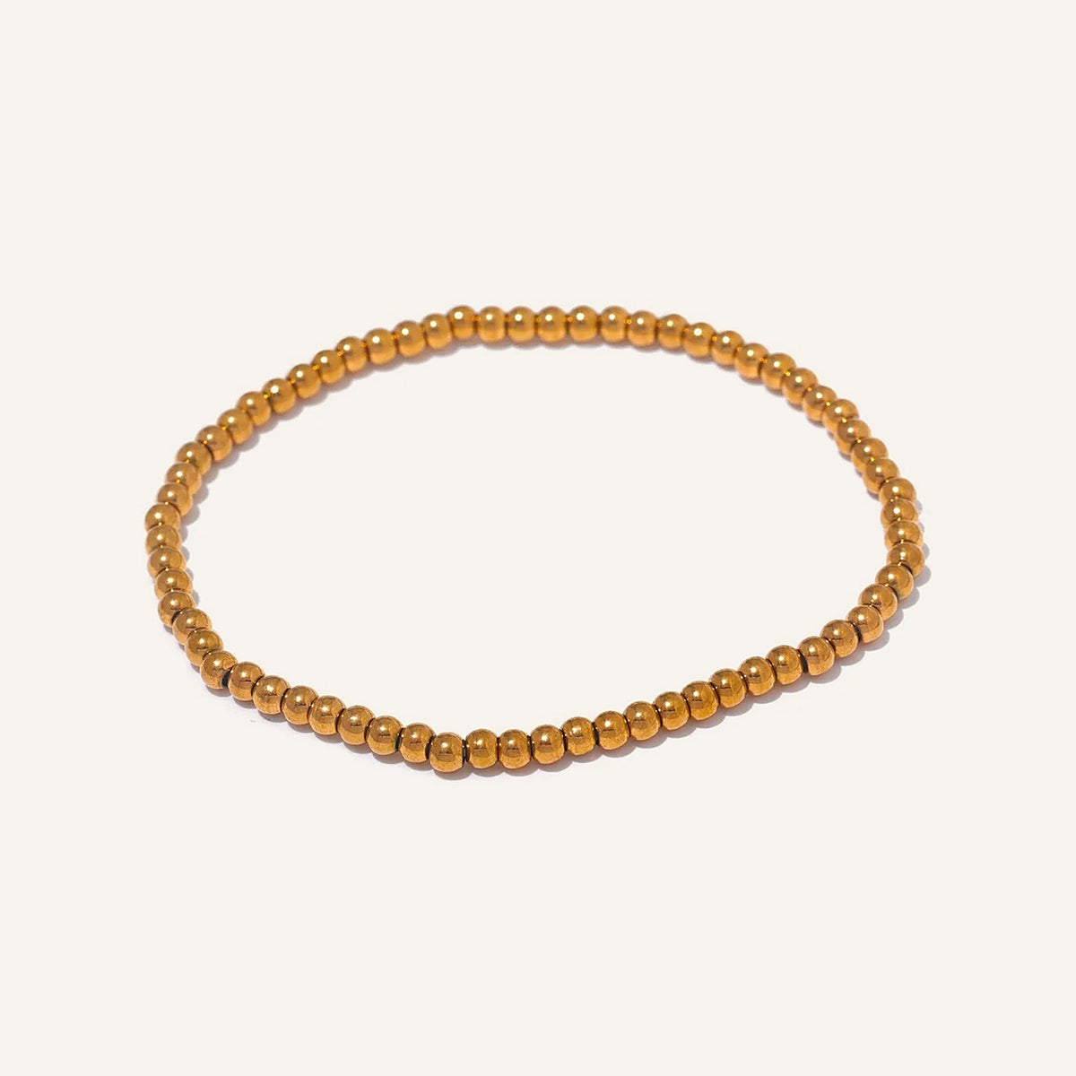 Bracelet élastique avec boules en acier, doré 3 mm, sur fond clair – Charmhabit