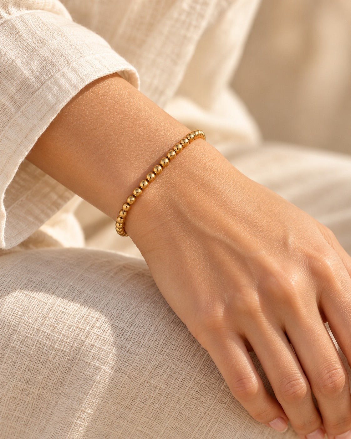 Bracelet élastique avec boules en acier, doré, porté – Charmhabit