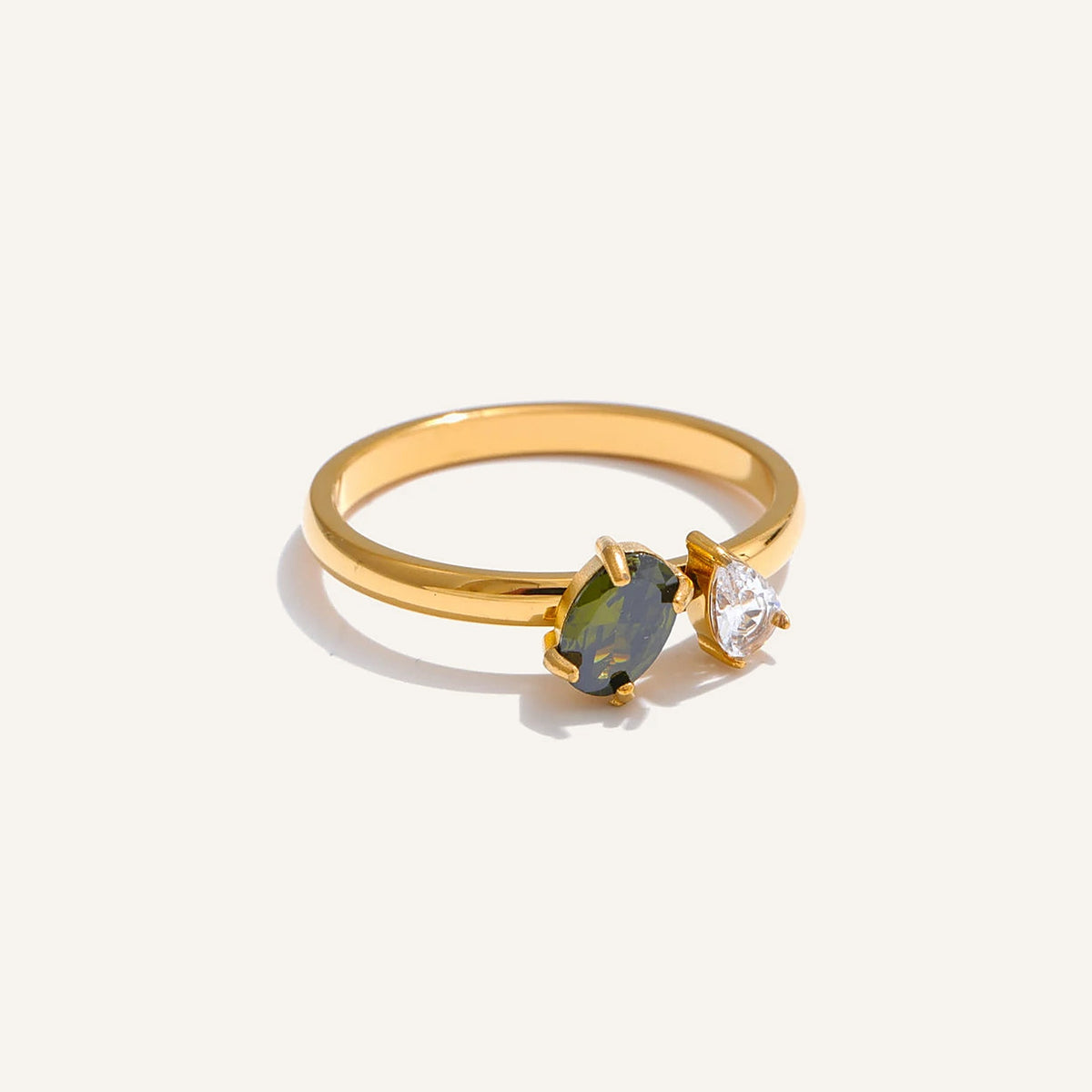 Ring mit grünem und weißem Zirkonia, auf hellem Hintergrund – Charmhabit