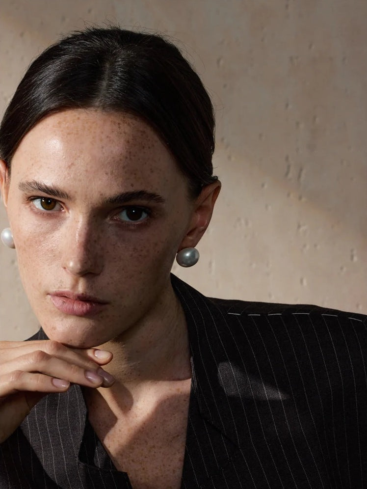 Clous d'oreilles ronds avec perle d'imitation, portés, gros plan – Charmhabit