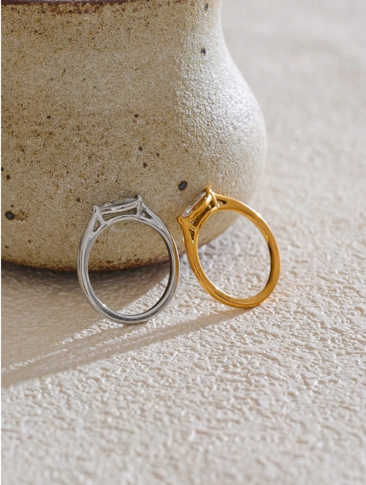 Marquise-cut cubic zirconia solitaire ring in gold and silver tones, beside a vase – Charmhabit
