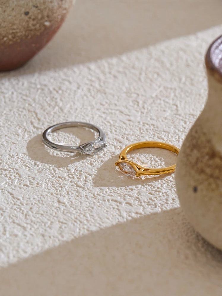 Marquise-cut cubic zirconia solitaire ring in gold and silver tones on a light surface – Charmhabit