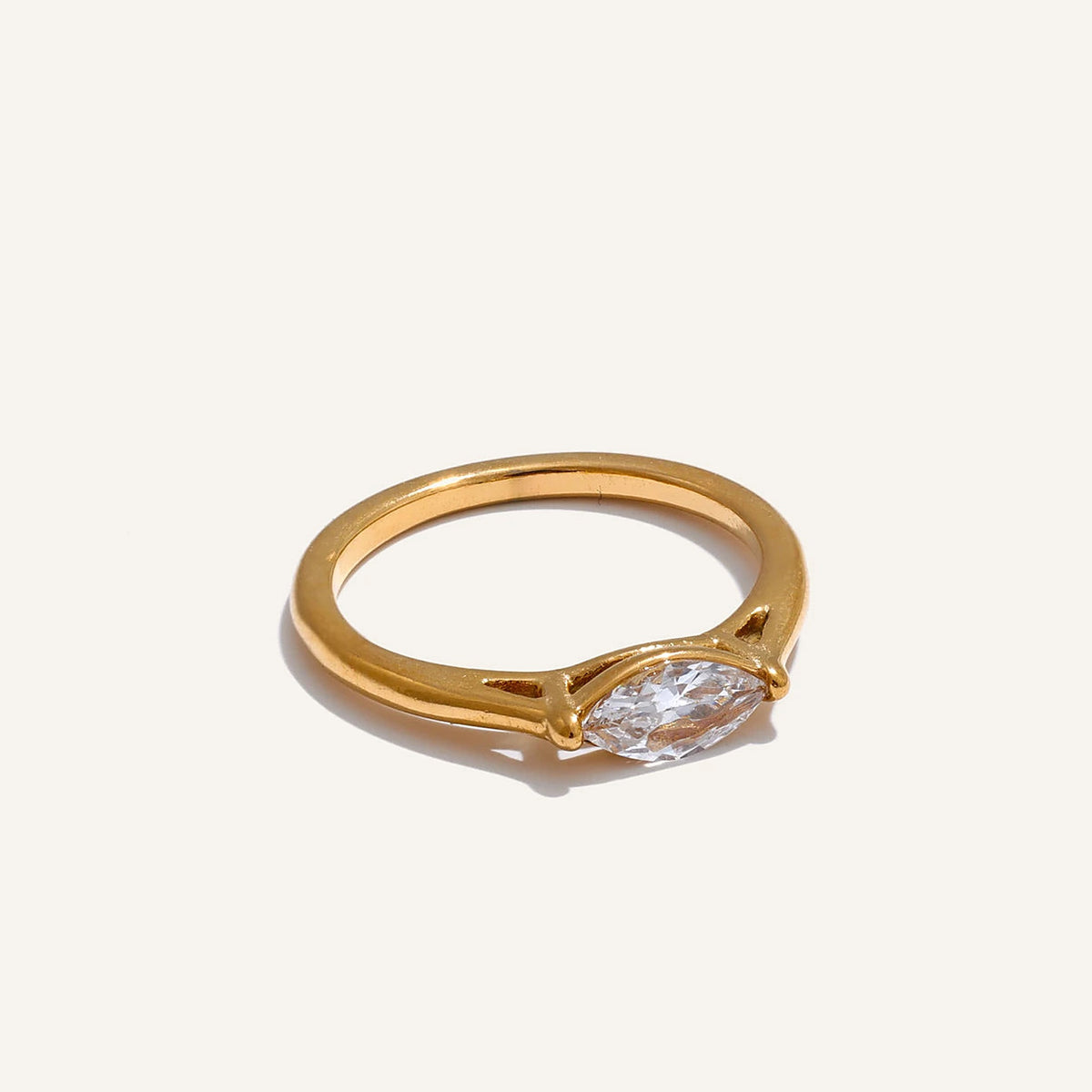Marquise-cut cubic zirconia solitaire ring, gold tone, on a light background – Charmhabit