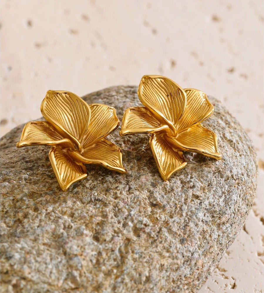 Statement bloem-oorknopjes in goud op een stuk steen – Charmhabit