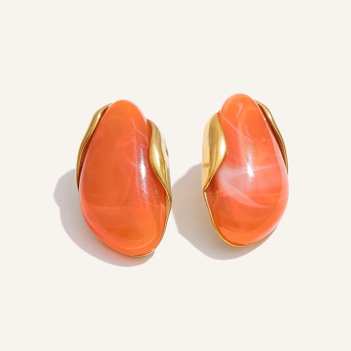 Statement resin stud earrings in orange on a light background – Charmhabit