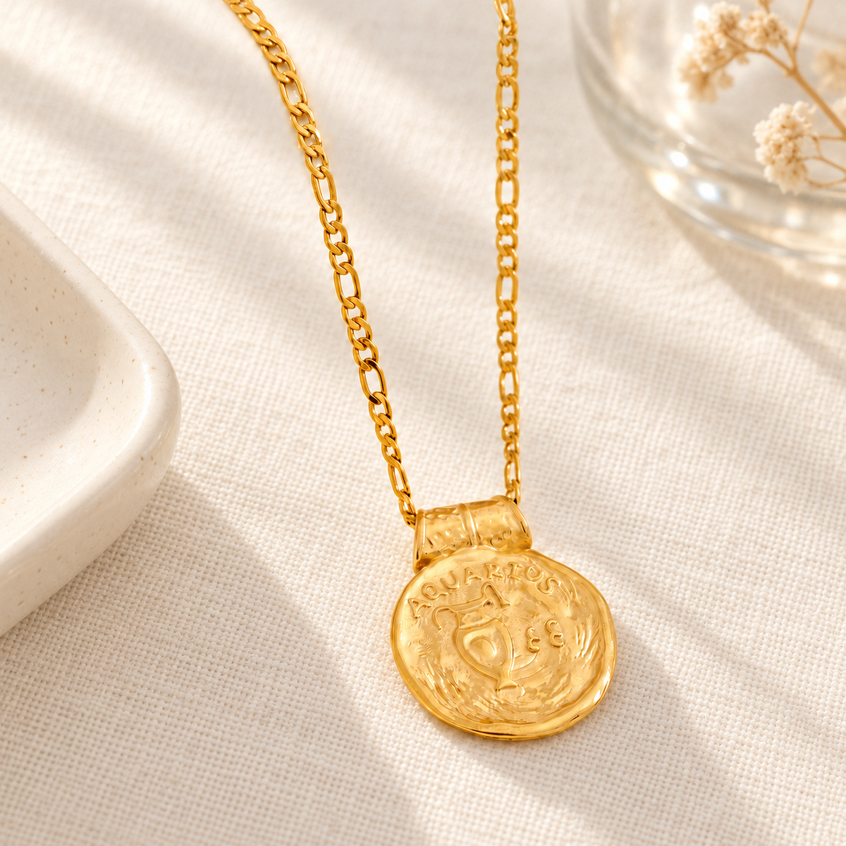 Goudkleurige sterrenbeeldketting met Waterman-hanger op licht linnen in een warme setting