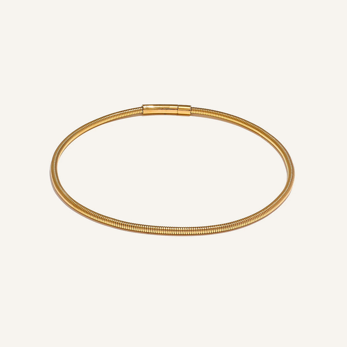 Rigid collar necklace in gold, gold tone, on a light background – Charmhabit